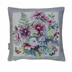 Eine sommerliche Wohlfühloase mit dem quadratischen Zierkissen Schmuckkörbchen. Das detailreiche Webmotiv zeigt einen prachtvollen Strauß aus zarten Schmuckkörbchen in Pink und Weiß, ergänzt durch filigrane Farne und flatternde Schmetterlinge.