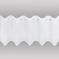 Die Stickereigardine Mila in 30 cm Höhe wurde vor einen grauen Hintergrund gehängt.