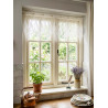 Elegante Scheibengardine aus weißer Spitze als dekorative Fenstergestaltung im hellen Landhaus-Ambiente.