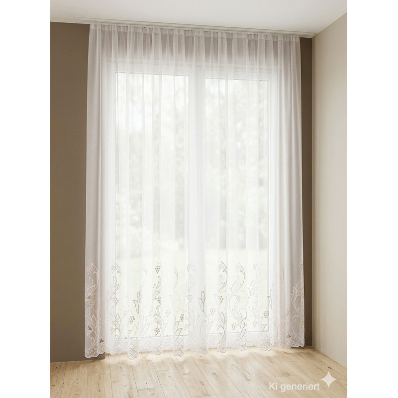Weiße, halbtransparente Store-Gardine mit floraler Plauener Spitze am Saum vor hellem Fenster im modernen Ambiente.