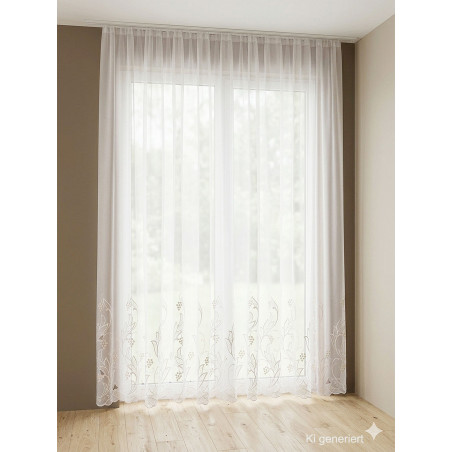 Weiße, halbtransparente Store-Gardine mit floraler Plauener Spitze am Saum vor hellem Fenster im modernen Ambiente.
