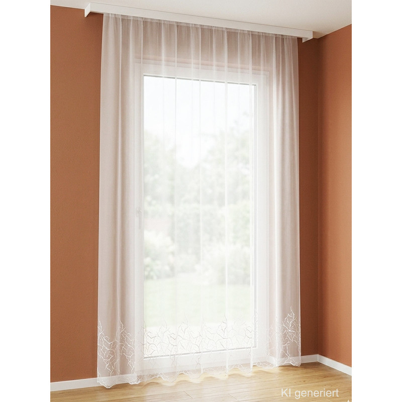 Halbtransparente weiße Gardine Annica mit floraler Stickerei am gewellten Abschluss vor einem Fenster.