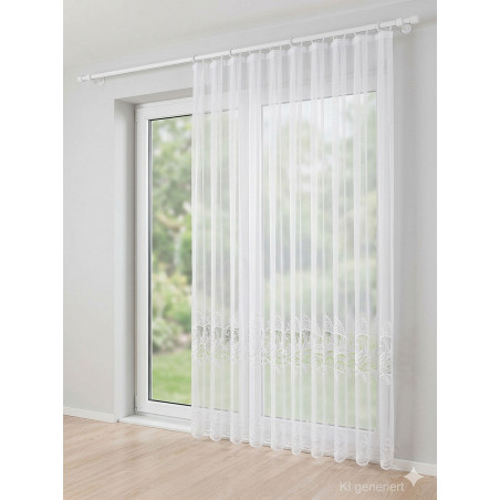 Bodenlanger weißer Fensterstore mit eleganter Stickerei-Borte an einer hellen Balkontür im Wohnbereich.