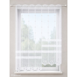 Halbtransparenter weißer Clipstore mit gestickten Blättern und Plauener Spitze am Fenster.