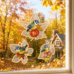Drei gestickte Fensterbilder mit Blaumeisen auf Herbstblättern im herbstlichen Ambiente am Fenster.