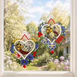 Zwei herzförmige Fensterbilder aus Spitze mit lustigen Käfern im sommerlichen Garten-Ambiente am Fenster angebracht.