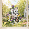 Gesticktes Fensterbild mit einer Katze auf einem Holzzaun im idyllischen Frühlings-Ambiente am Fenster.