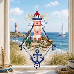 Maritimes Spitze-Fensterbild mit Leuchtturmmotiv vor einem hellen Fenster mit Ausblick auf das weite Meer.