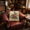 Gobelin-Dekokissen mit Bücher-Motiv auf einem dunklen Chesterfield-Ledersessel im gemütlichen Lesezimmer.