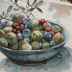Nahaufnahme von gewebtem Gobelinstoff mit mediterranem Motiv einer Tonschale gefüllt mit Oliven und Zweigen.