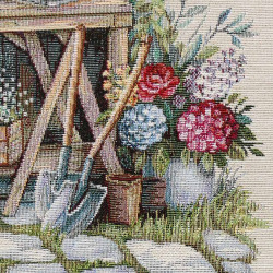 Detail von Gobelin-Sofakissen: Fest gewebte Struktur mit bunten Hortensien, Rosen und Gartengeräten in Nahaufnahme.