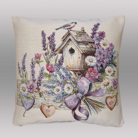 Kissenbezug mit eingewebtem Vogelhaus- und Lavendel-Motiv, lila Schleife und Deko-Herzen auf hellem Grund.
