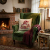 Dekokissen mit strickendem Wichtel in gemütlichem Wohnzimmer mit Kamin. Heimtextilien für Landhaus-Look.