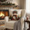 Gobelin-Dekokissen mit Schneemann im modernen Wohnzimmer auf grauem Sessel neben einer gemusterten Kuscheldecke.