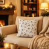 Buntes Dekokissen mit Schneemann-Muster im gemütlichen Wohnzimmer auf einer hellbeige Couch.