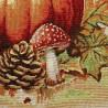 Detailaufnahme: Gobelin-Dekokissen mit gewebtem Kürbis-, Fliegenpilz- und Tannenzapfen-Muster in warmen Herbstfarben.