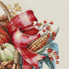 Detailaufnahme von gewebtem Gobelin-Stoff mit Herbstmotiv aus Erntekorb, Mais und roter Schleife.