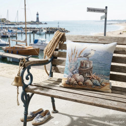 Maritimes Gobelin-Dekokissen mit Möwen-Motiv auf einer Holzbank an der Promenade für Sommerdeko.