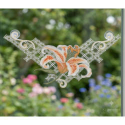 Plauener Spitze Fensterbild mit orangefarbener Lilie, per Saugnapf am Fenster befestigt vor Gartenkulisse.
