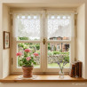 Transparente Kurzgardine aus naturweißer Plauener Spitze mit Blumenmuster am Fenster im gemütlichen Landhausstil.