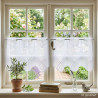 Weiße Scheibengardine aus Voile mit feiner Liniengrafik am Landhaus-Fenster mit Olivenbaum.