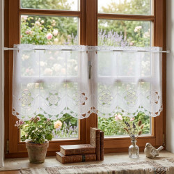 Weiße Scheibengardine aus Voile mit Blüten-Stickerei am Holzfenster im gemütlichen Landhausstil.