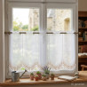 Mittellange Scheibengardine aus halbtransparentem Voile mit beige-rosefarbener Bogen-Stickerei am dekorierten Fenster.