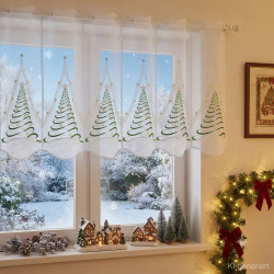 Halbtransparente Scheibengardine mit Weihnachtsbaummotiv im festlich dekorierten Zimmer mit Lichterkette.