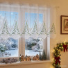 Halbtransparente Scheibengardine mit Weihnachtsbaummotiv im festlich dekorierten Zimmer mit Lichterkette.