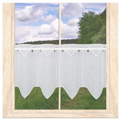 Weiße Scheibengardine mit geometrischer Stickerei und spitzem Abschluss vor Wiesenlandschaft. Elegante Heimtextilien. 30 cm hoch