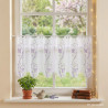 Kurze weiße Scheibengardine aus Voile mit lila Lilien-Stickerei im dekorierten Fenster.