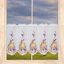 Weiße Plauener Spitze Kurzgardine mit gelben Küken, lilafarbenen Schleifen und Blumen im Fenster.