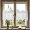 Weiße Kurzgardine aus Plauener Spitze mit detailreicher Stickerei am Fenster im Zimmer mit Blick ins Grüne als Heimtextilien.