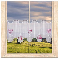 Weiße Stickereigarderine in transparenter Optik mit verspielten pinken Blütenmotiven am Holzfenster.