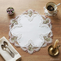 Besticktes Spitzendeckchen als Heimtextilien-Tischdeko auf Holztisch mit Kaffeetasse und Kerzenständer arrangiert.