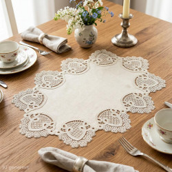 Ovale Spitze-Mitteldecke in Creme auf Holz-Esstisch dekoriert mit Geschirr, Blumen und Kerzen im Landhausstil.