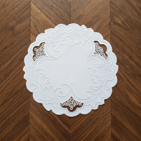 Runde Plauener Spitze Tischdecke in Schneeweiß mit floraler Stickerei flach auf Holzoberfläche präsentiert.