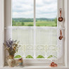 Scheibengardine in Weiß mit feiner Stickerei am Küchenfenster im stilvollen Landhausstil.