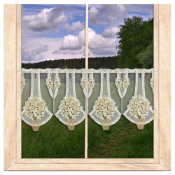 Transparente Scheibengardine aus Plauener Spitze mit gelben Rosenbäumen im Topf dekoriert am Fenster.