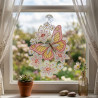 Fensterbild aus Plauener Spitze mit rosa Schmetterling und Blüten am Fenster dekoriert im Raumambiente.