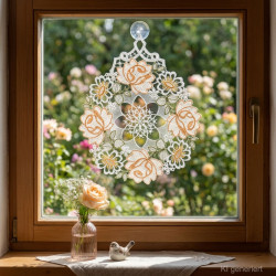 Fensterbild aus Plauener Spitze mit orange-grüner Blütenstickerei am Fenster dekoriert im Raumambiente.